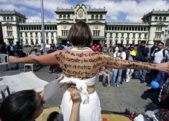 Una mujer se pinta su cuerpo en la Plaza de la Constitucion en el marco del Dia Internacional para la Erradicacion de la Violencia contra la Mujer en Ciudad de Guatemala, el 25 de noviembre de 2006. En lo que va del ano se han registrado mas de 540 homicidios de mujeres, superando en cifra las estadisticas del 2005.    AFP PHOTO/Orlando SIERRA (Photo by ORLANDO SIERRA / AFP)