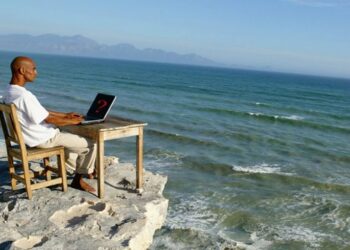 Hombre trabajando frente a la playa con red 5G