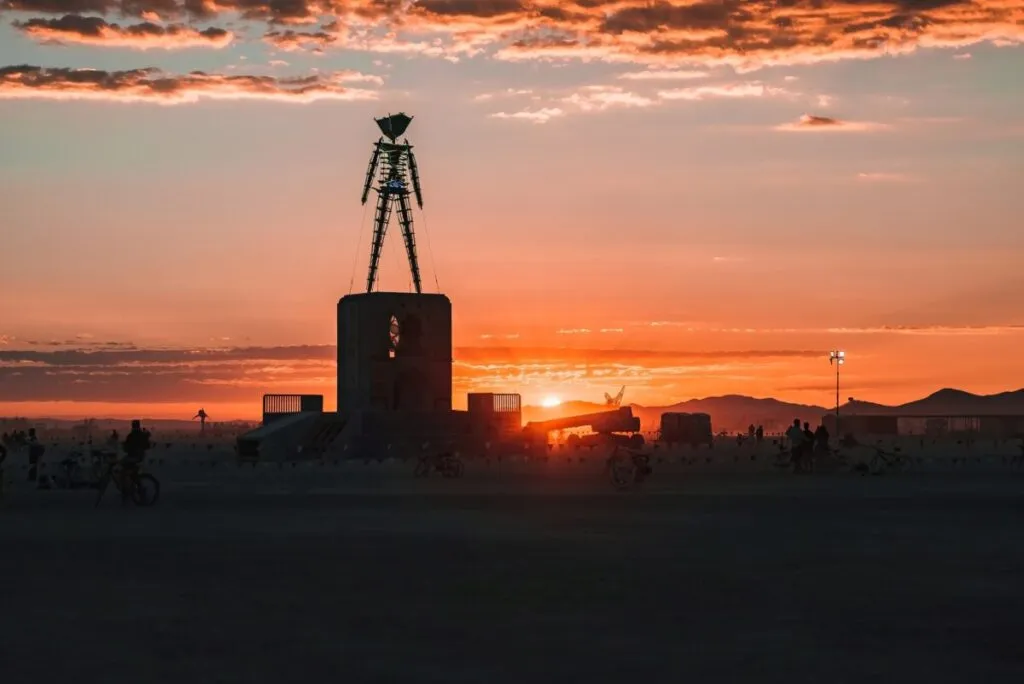 Estructura icónica de Burning Man al atardecer en Black Rock City, Nevada, tras un día marcado por tormentas y lluvias intensas.