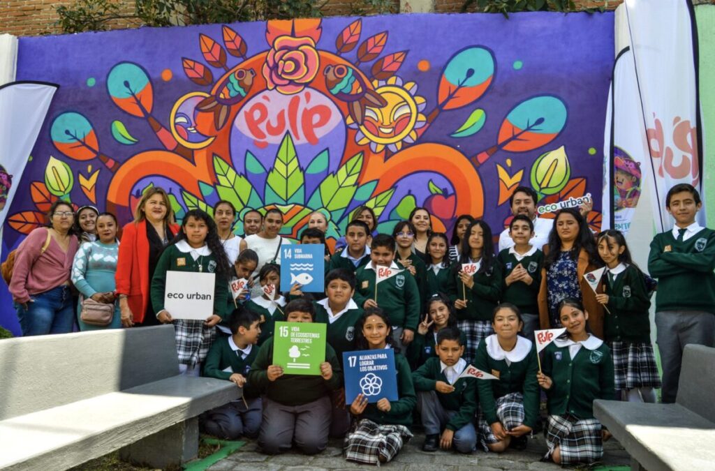 Inauguración del mural de Mayahuel en Metepec, con autoridades educativas, representantes de AJEMEX y Eco Urban celebrando el arte y la sostenibilidad.