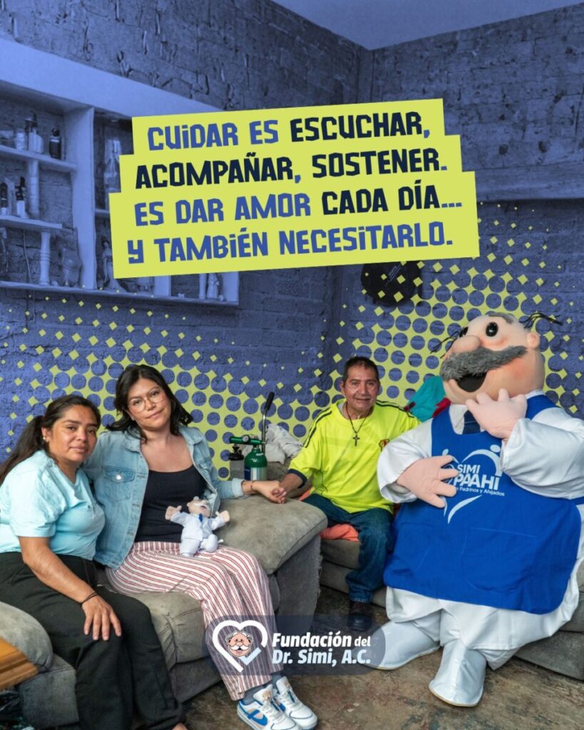 Dr. Simi sentado junto a una de las familias beneficiarias de su programas de ayuda.