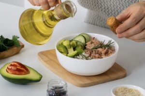 Plato colorido con ensalada mediterránea, aceite de oliva y vegetales frescos, tal como lo promueve Grupo Kosmos.