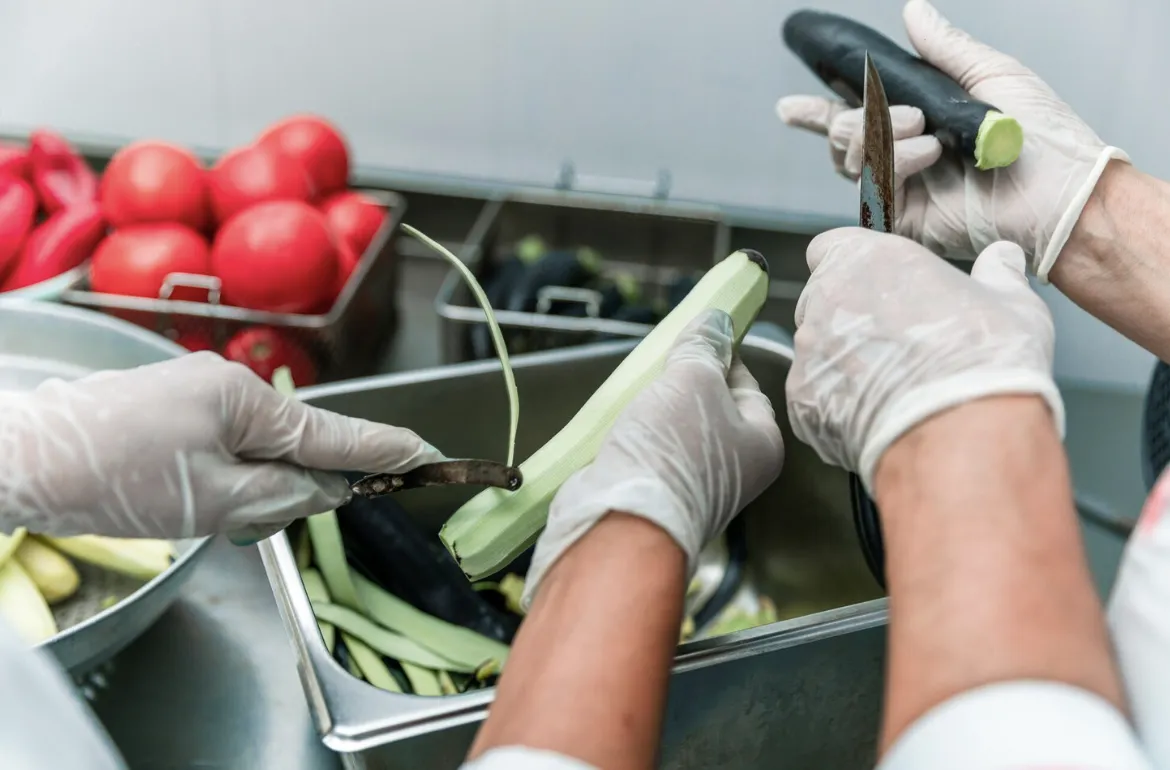 Personal de cocina industrial supervisado bajo protocolos de higiene y seguridad alimentaria como los que implementa Grupo Kosmos.
