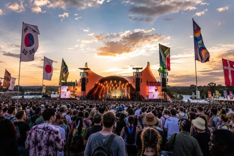 Miles de personas asisten a un festival internacional de música con artistas y banderas de distintos países, reflejando la diversidad de la cultura contemporánea. monocultura