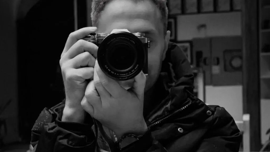 Fotógrafo capturando imágenes con una cámara profesional, representando el papel de la fotografía en la preservación de la cultura nómada y el patrimonio impulsado por la UNESCO.