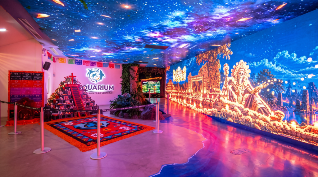 Altar monumental del Día de Muertos en el Aquarium del Puerto de Veracruz, con pantallas inmersivas y decoración tradicional mexicana.