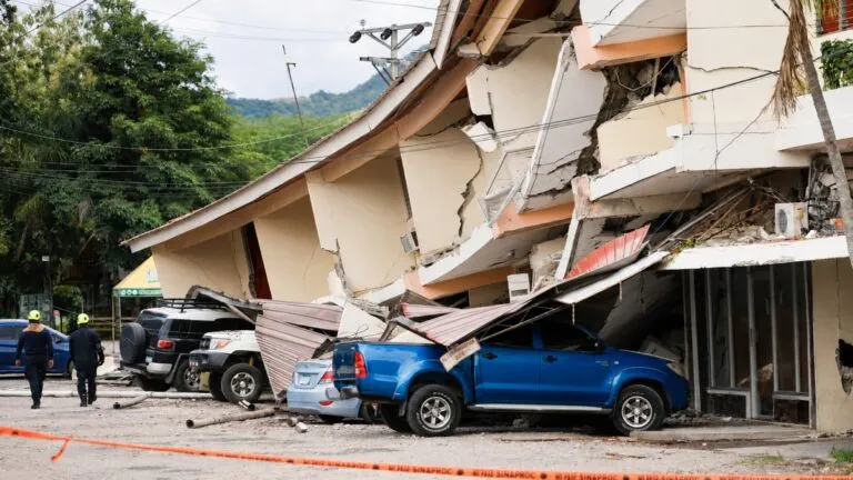 Edificios y calles de Panamá afectados por un terremoto, con personal de emergencia realizando labores de evaluación.
